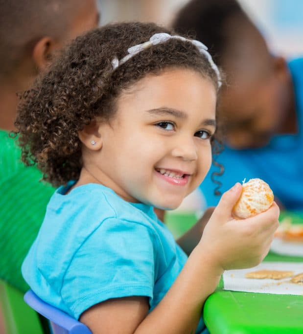 Child enjoying a snack during a First Step Nursery mealtime